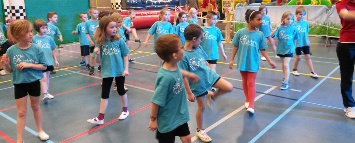 leerlingen met allemaal hetzelfde blauwe turn t-shirts aan in een sportzaal