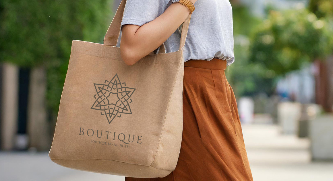 shoppende dame loopt in een zonnige straat met een bedrukte wandeltas om haar schouder