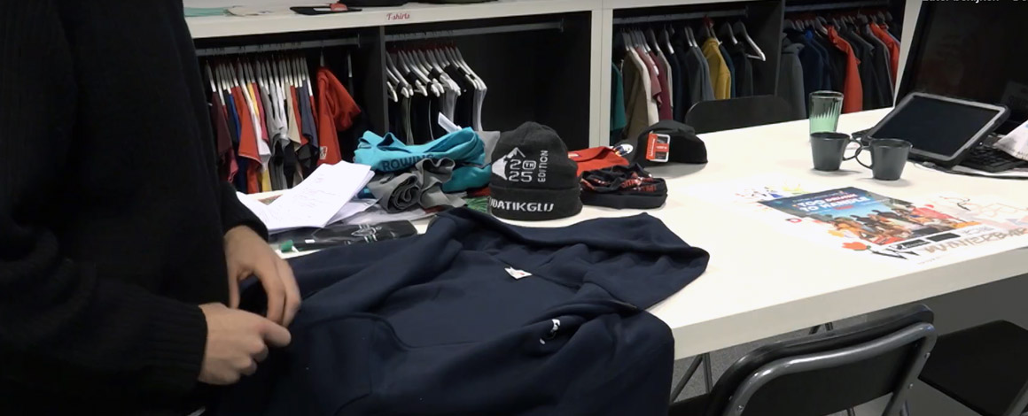 iemand bekijkt een hoodie in de showroom tijdens het kiezen van bedrukte promotiekleding