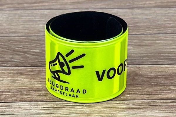 reflecterend geel klaparmbandje met zwarte bedrukking voor de Jeugdraad van Aartselaar